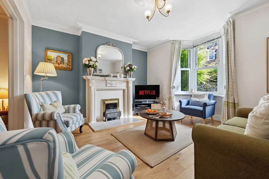 Living room with striped armchairs and a period fireplace