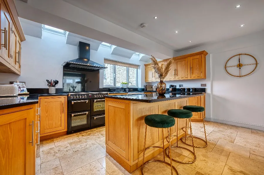 Kitchen with oak units and green bar stools